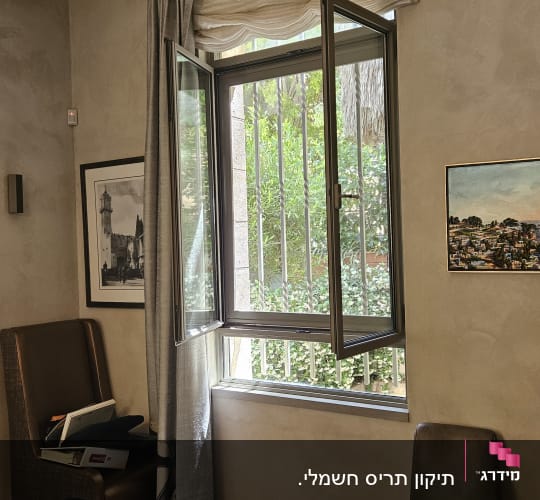 חלון פתוח עם תריסים מתכתיים וילון בצד